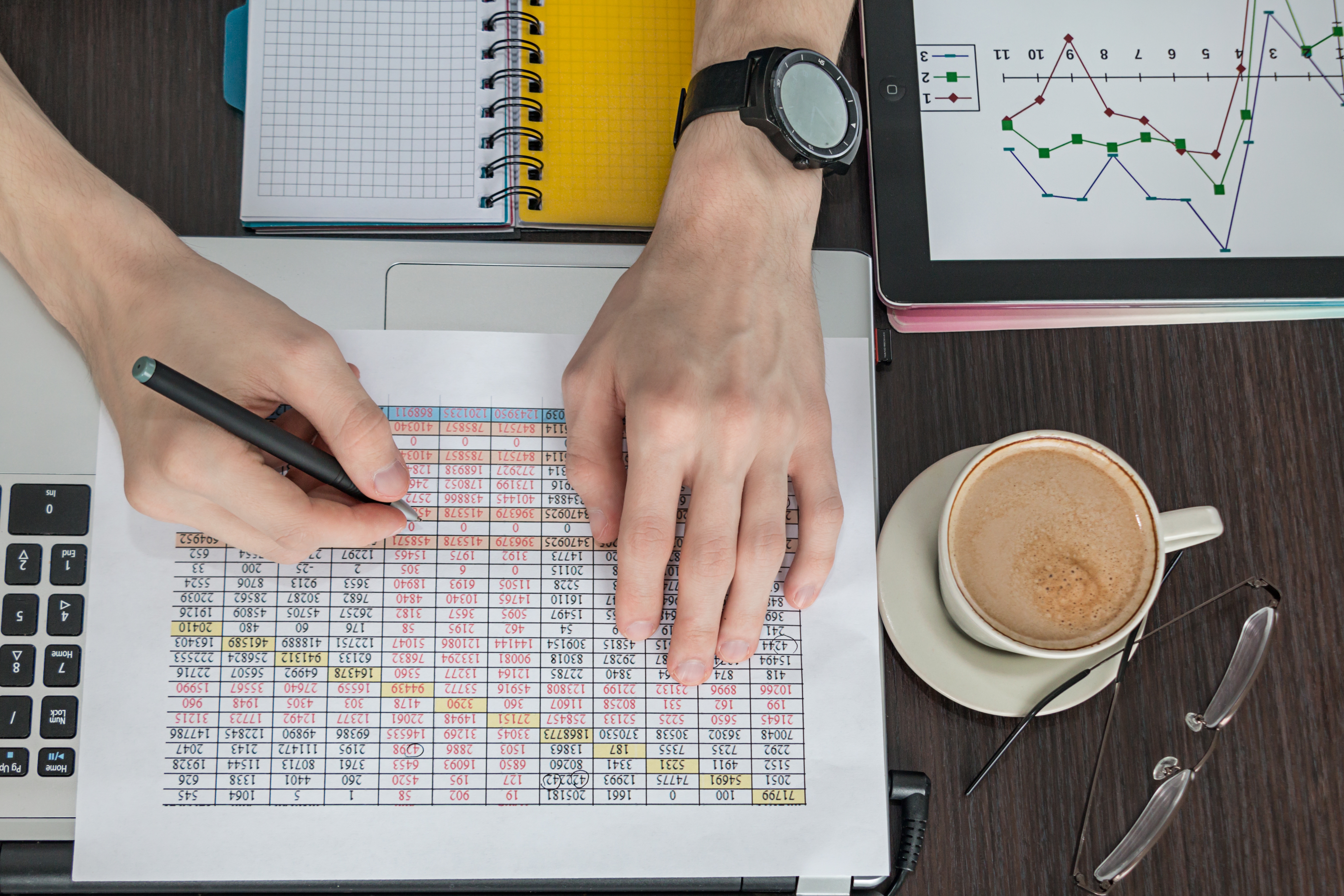 Mann schaut Statistiken an und notiert etwas